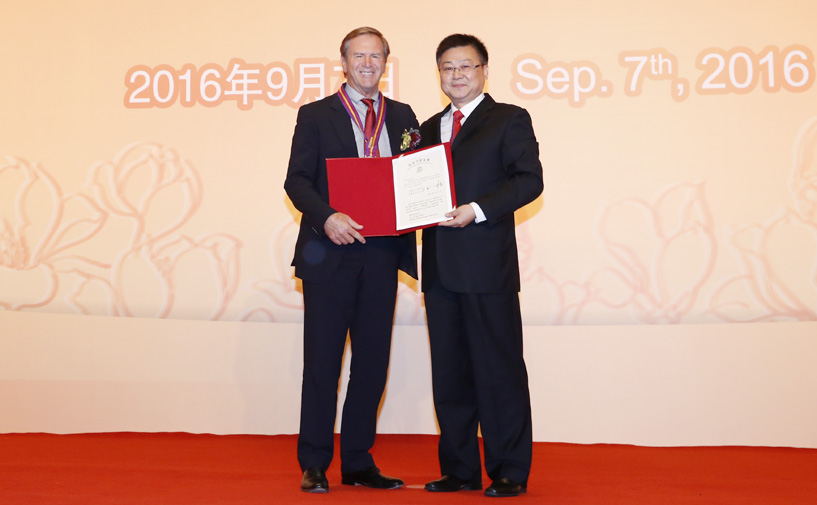 上海市政府外办主任张小松向万年达授予“白玉兰纪念奖”奖牌和证书