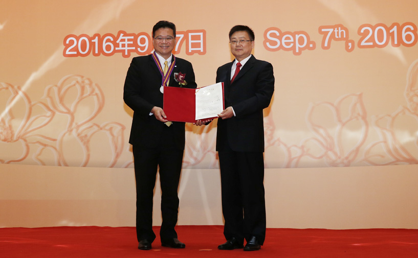 上海市政府外办主任张小松向莫兴萃授予“白玉兰纪念奖”奖牌和证书